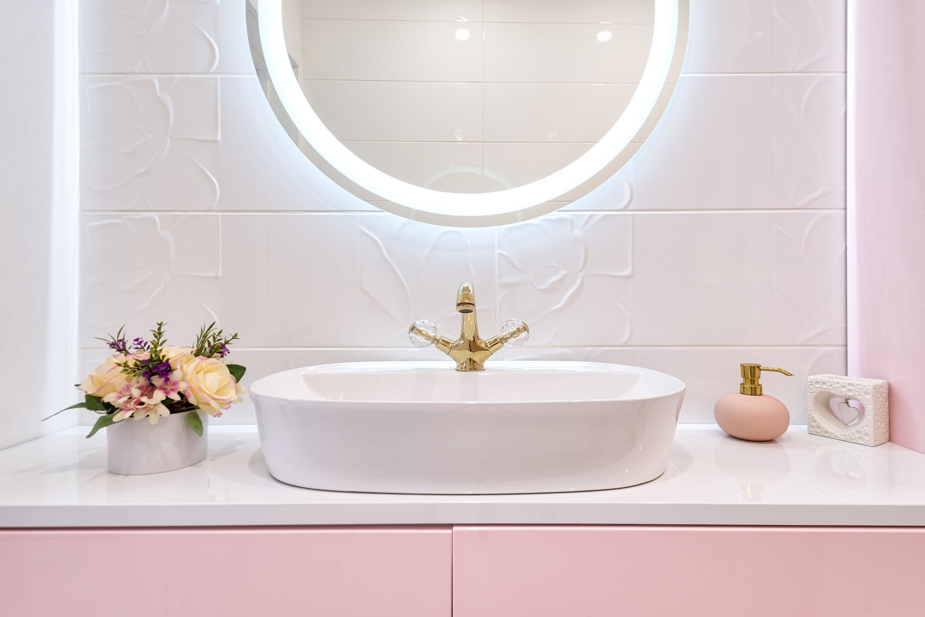shiny mirror hanging on wall above sink in bathroom