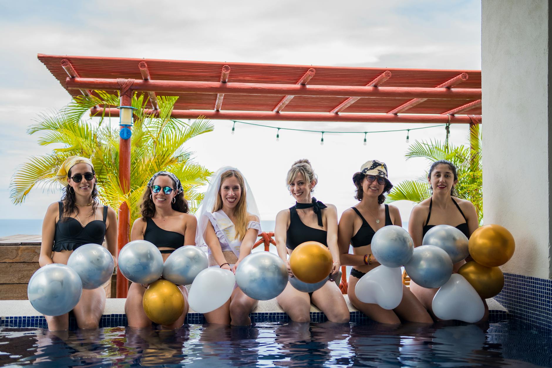 woman sitting in swimming pool for bride party