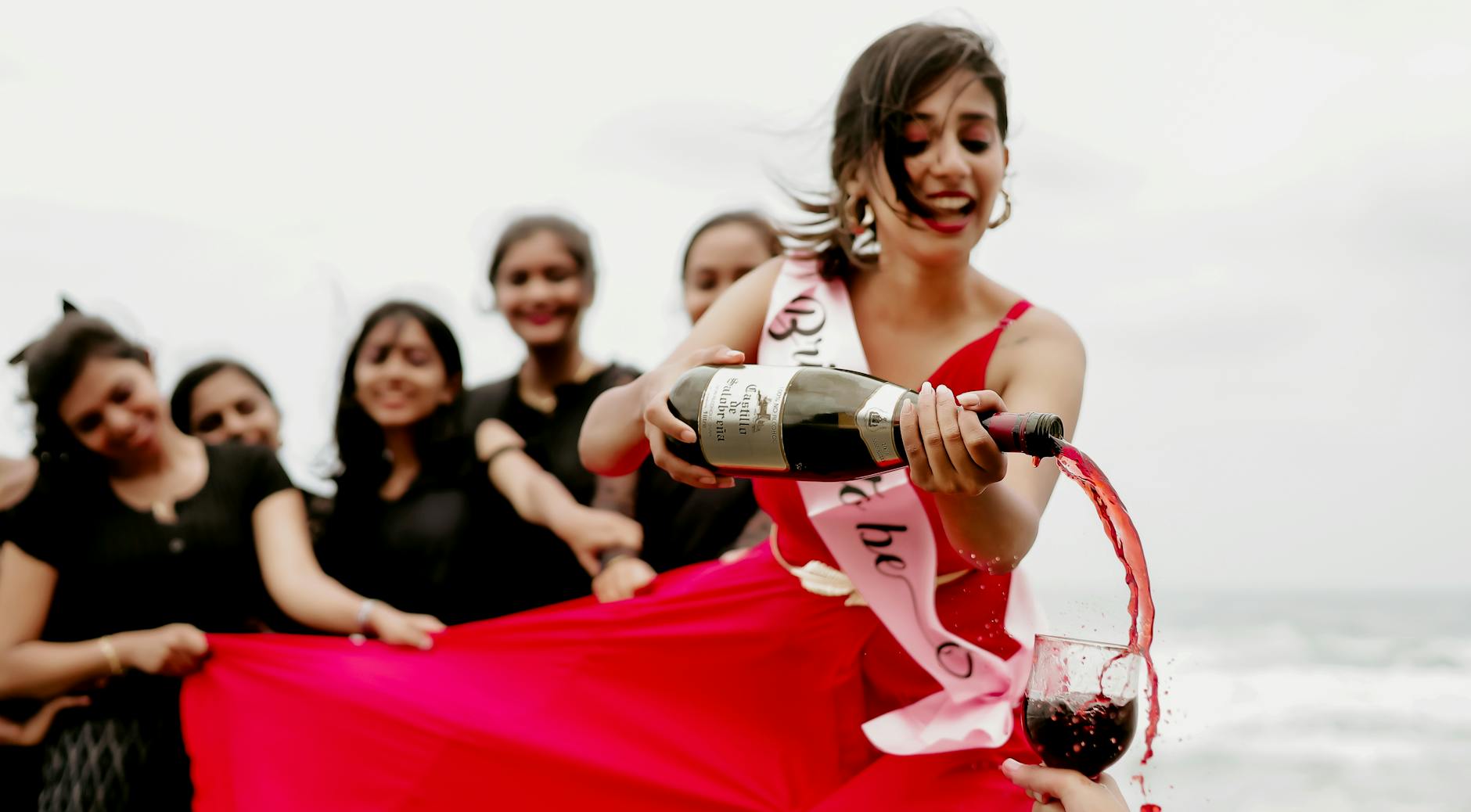 woman pouring wine on a bridal party