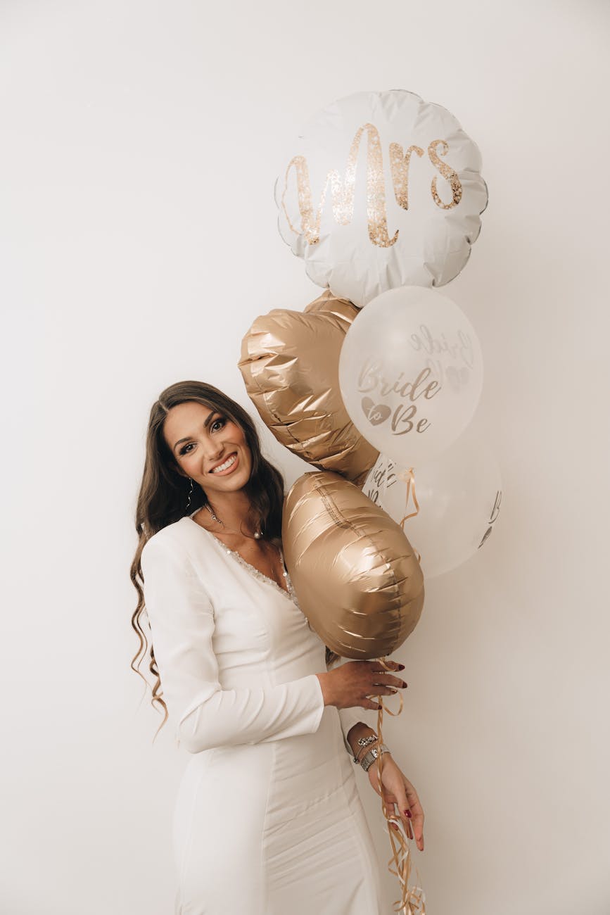 woman in a white dress holding balloons