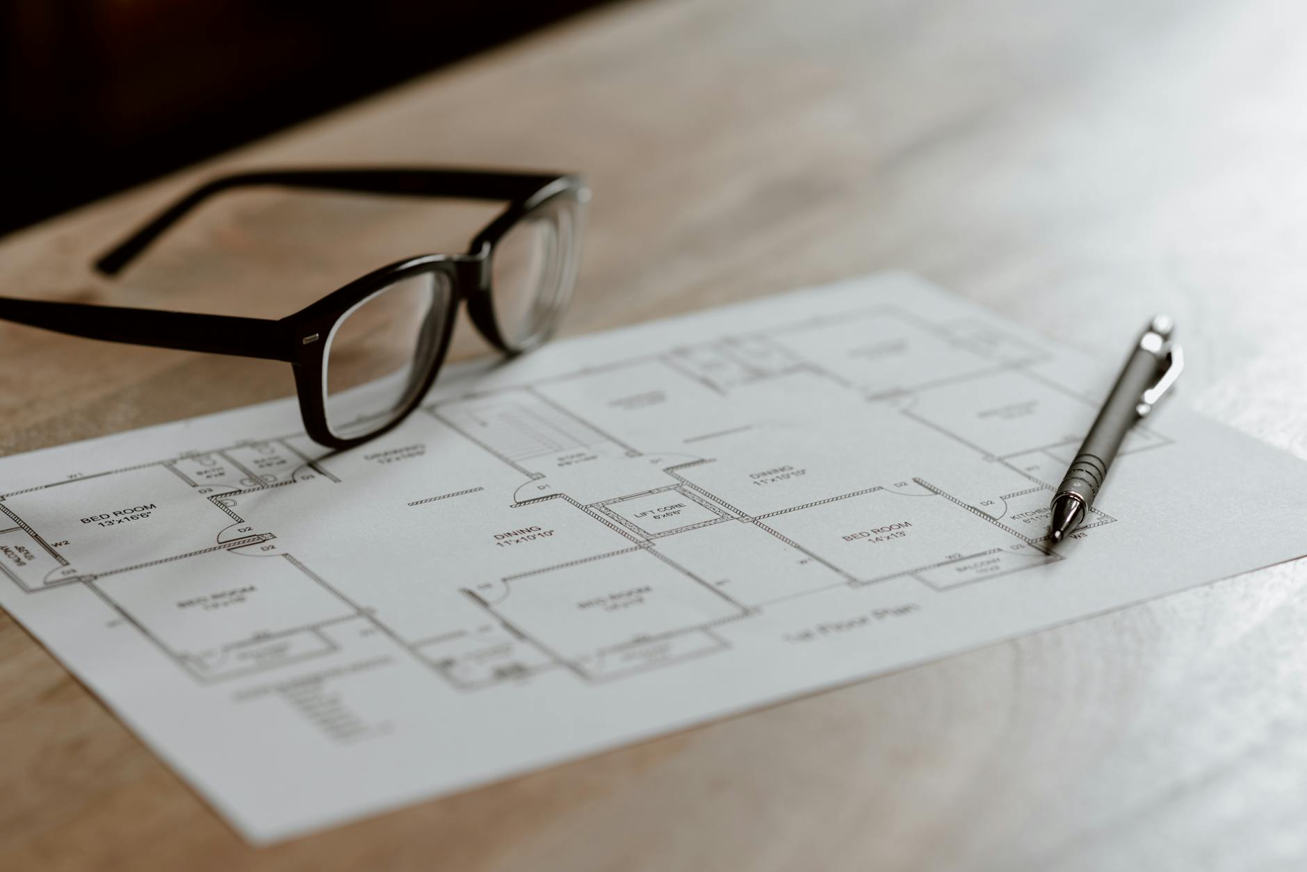 glasses and pen on paper on table