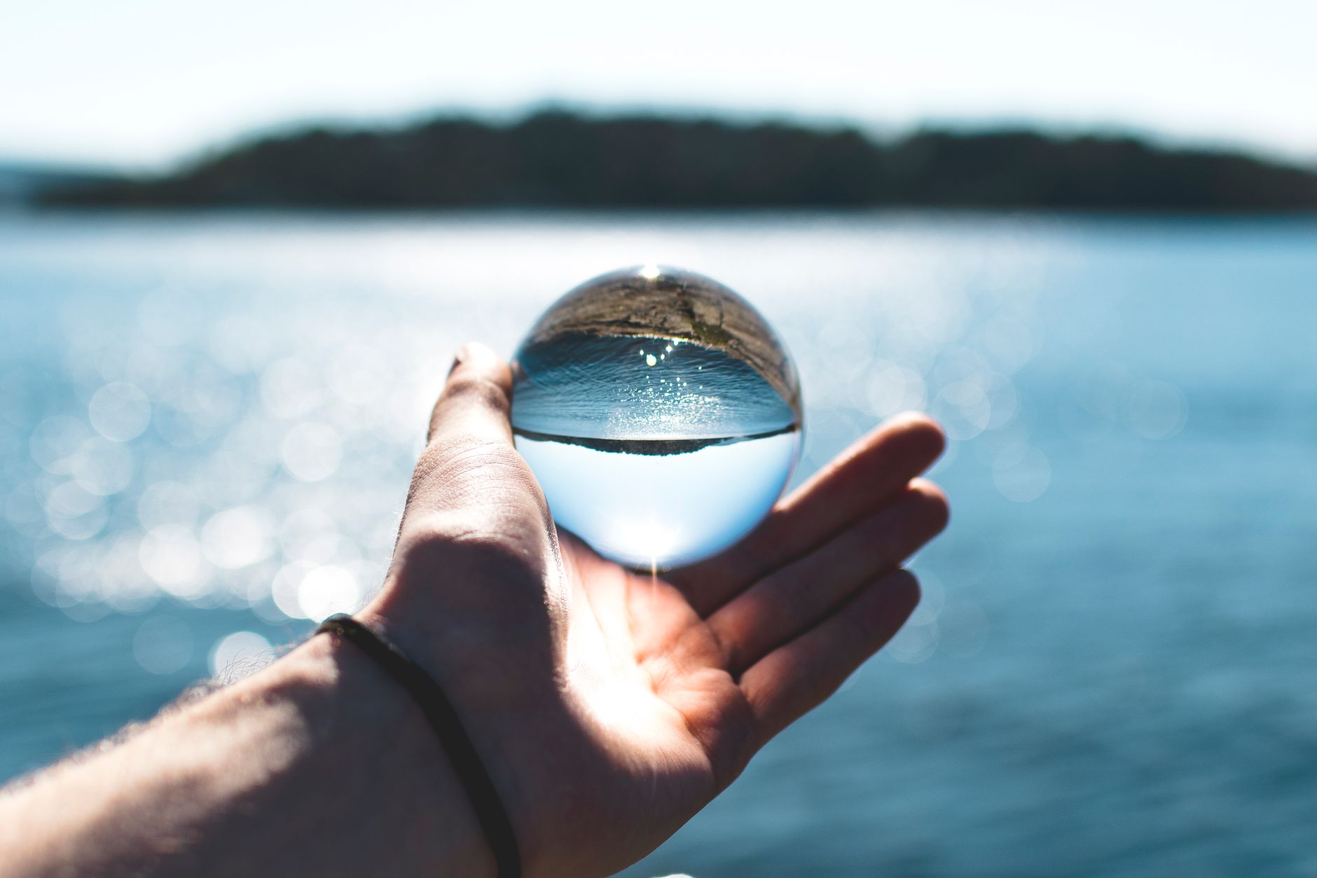 bokeh photography of person holding water drop