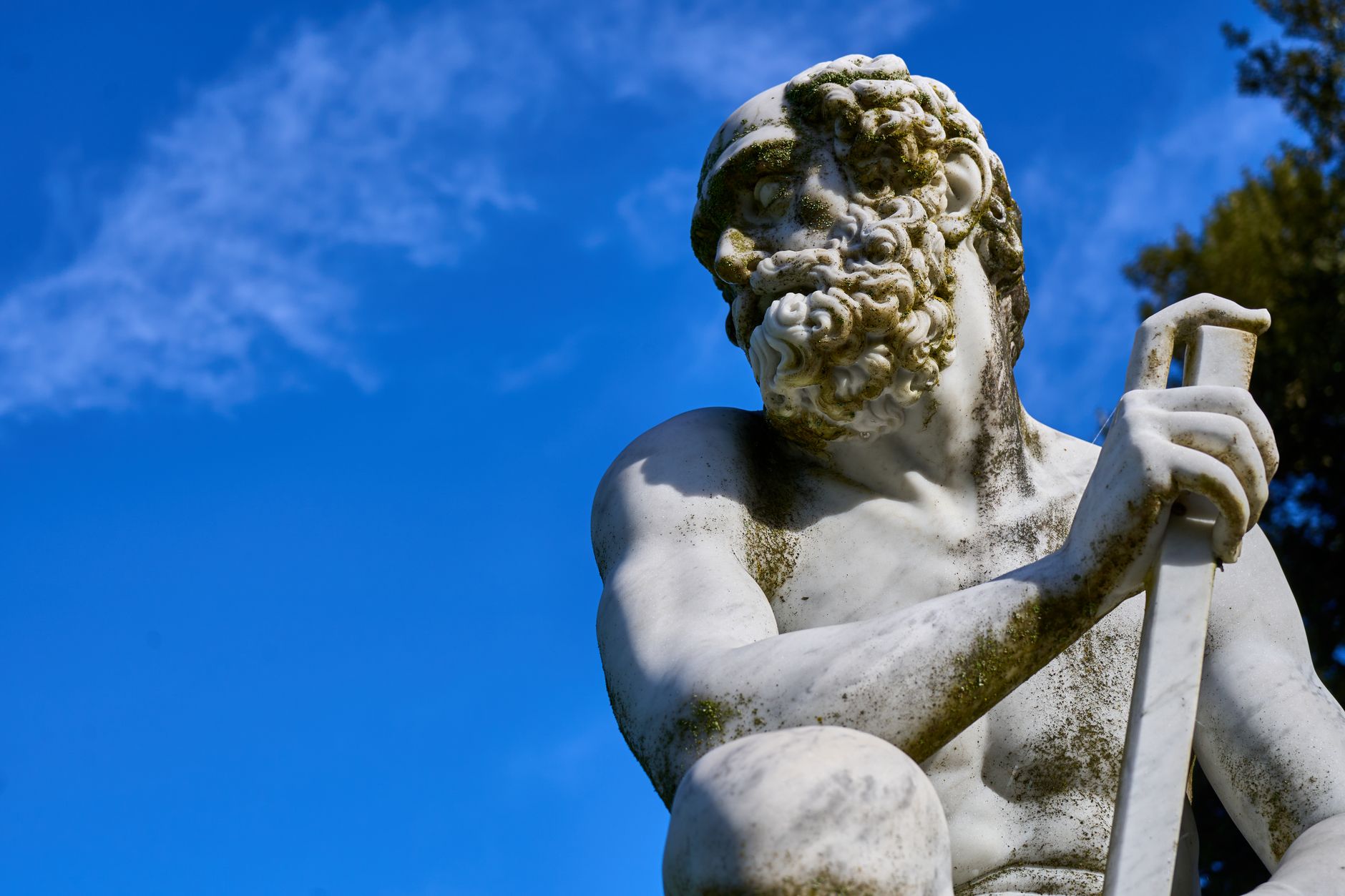 classical marble statue under a clear blue sky