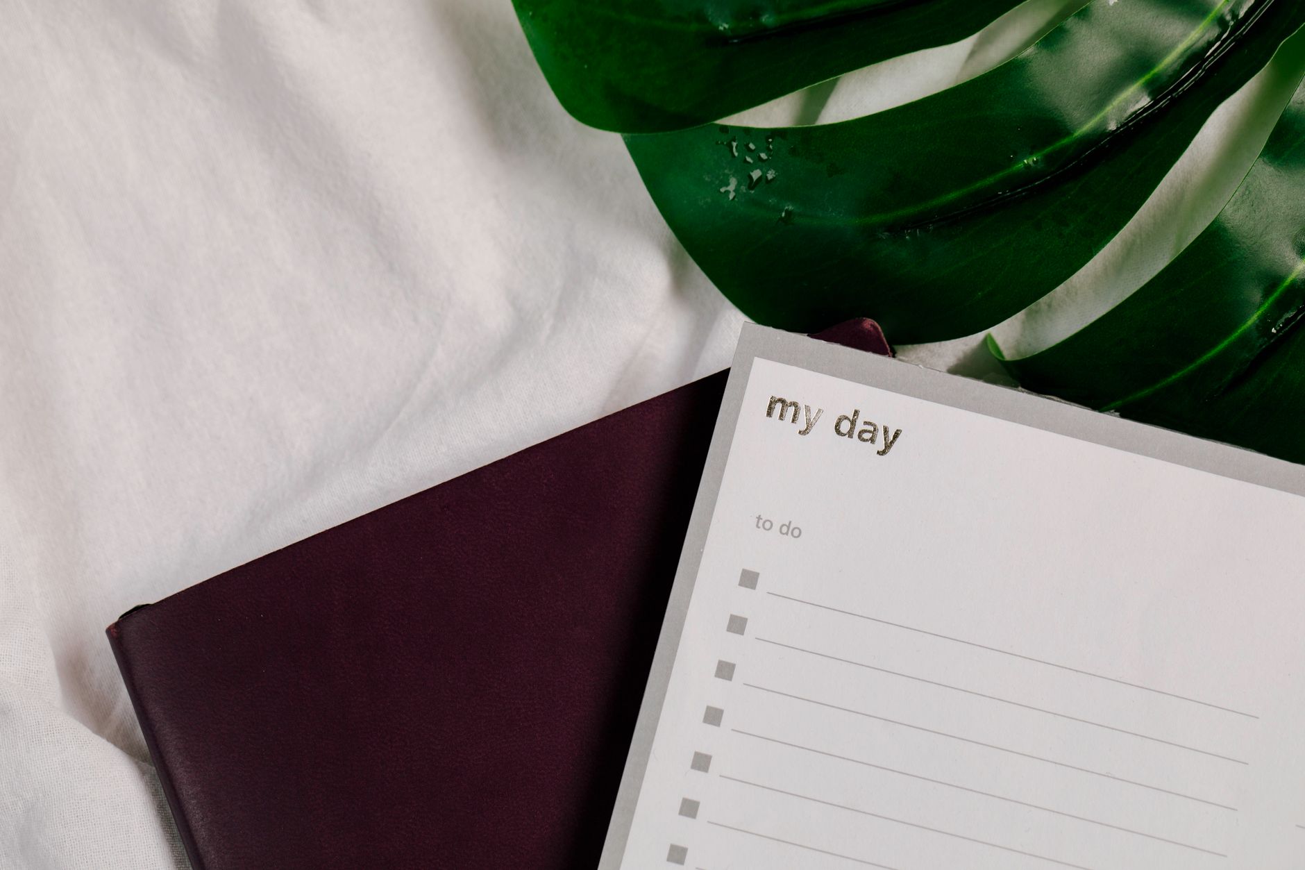 a paper and a notebook on white textile