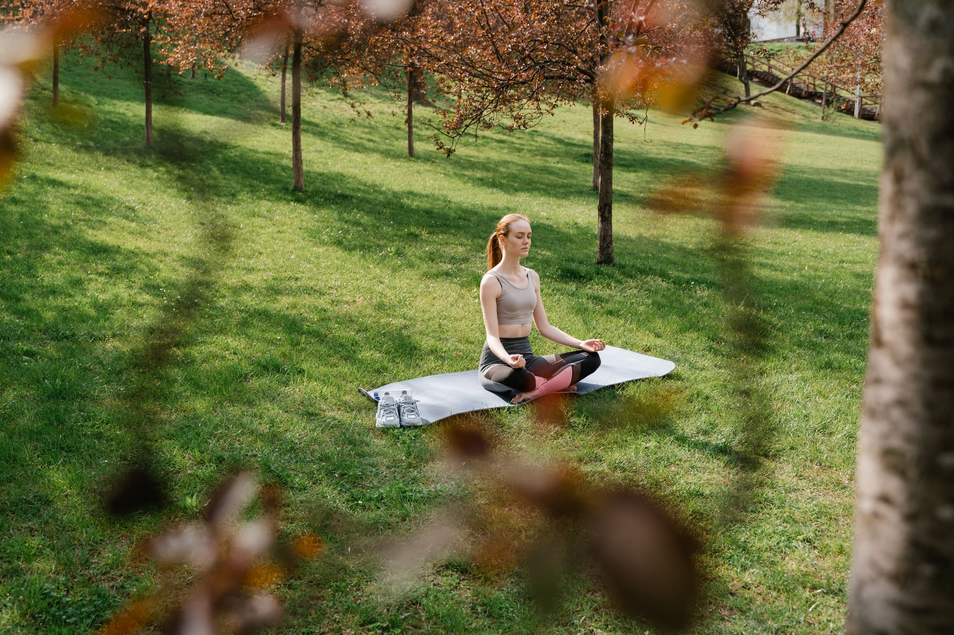 a woman meditating at a park