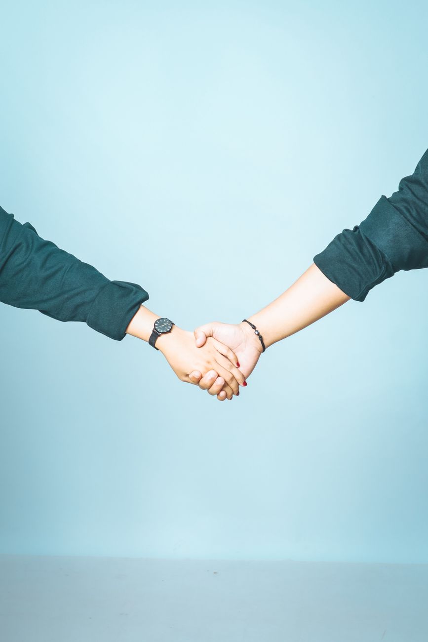 holding hands against blue background