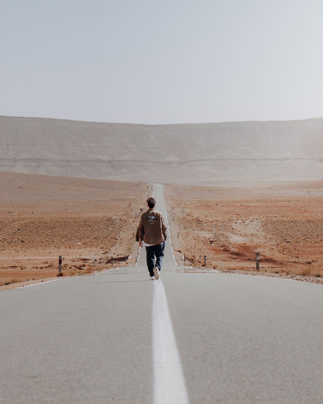 lone walker on desert road in morocco