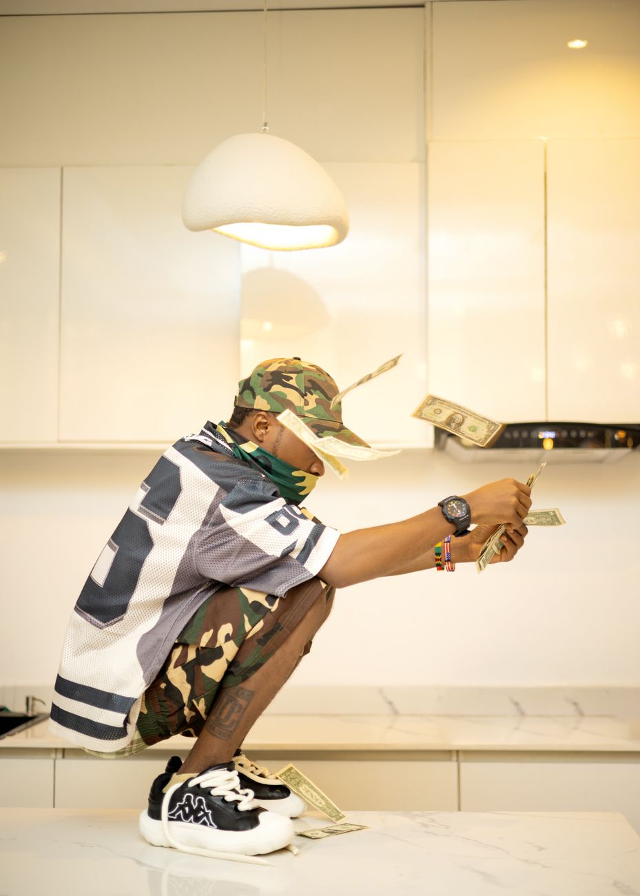 young man in camo with floating cash indoors