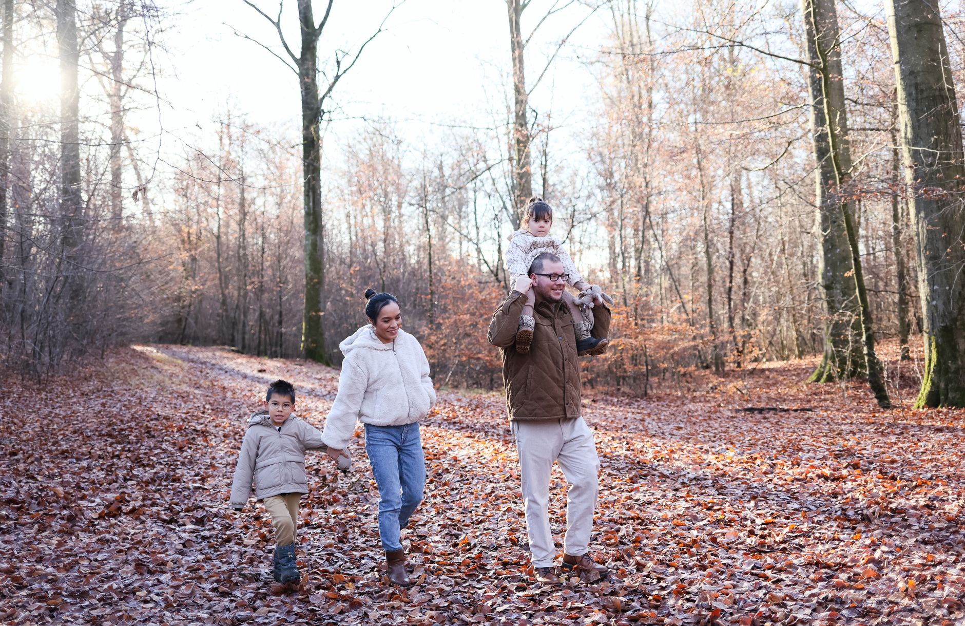 family stroll through autumn forest path