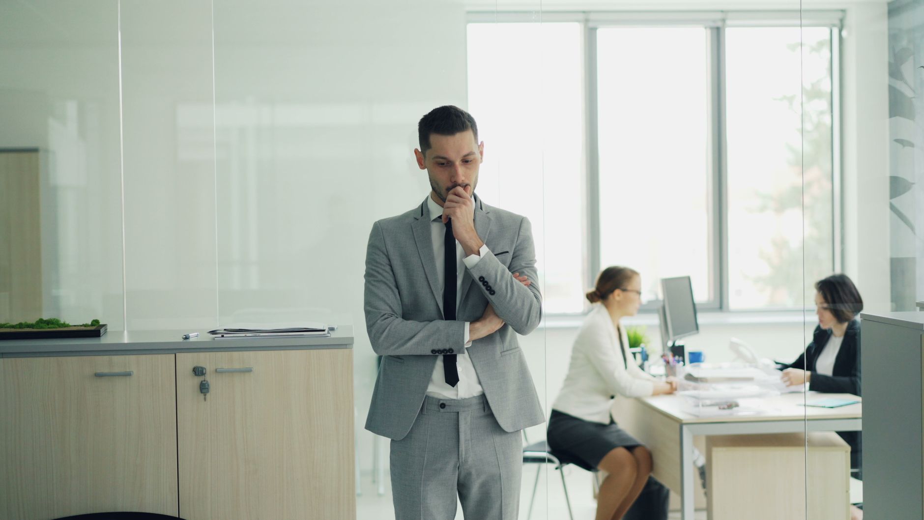businessman in office pondering decision