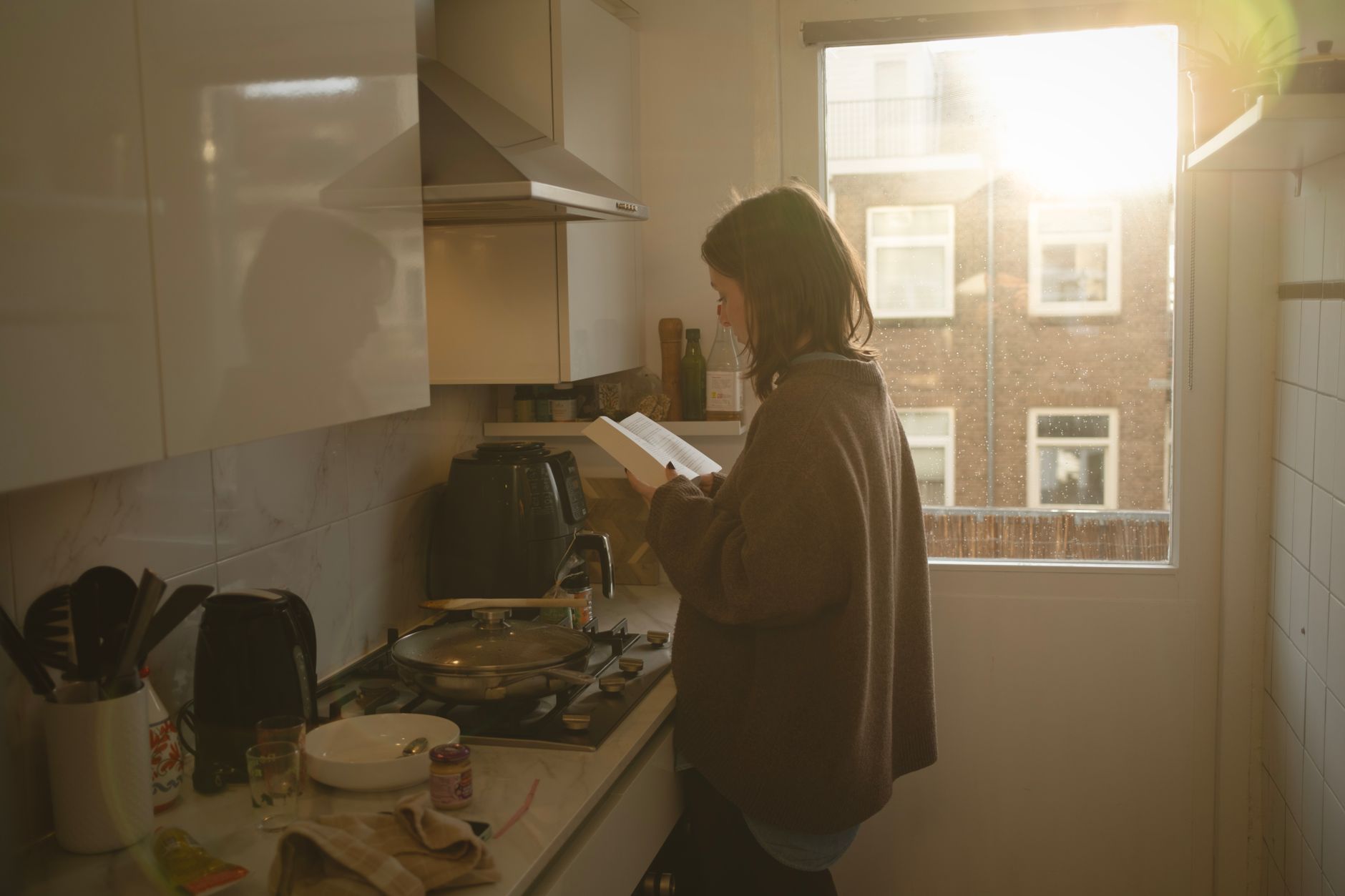 woman reading in sunlit kitchen