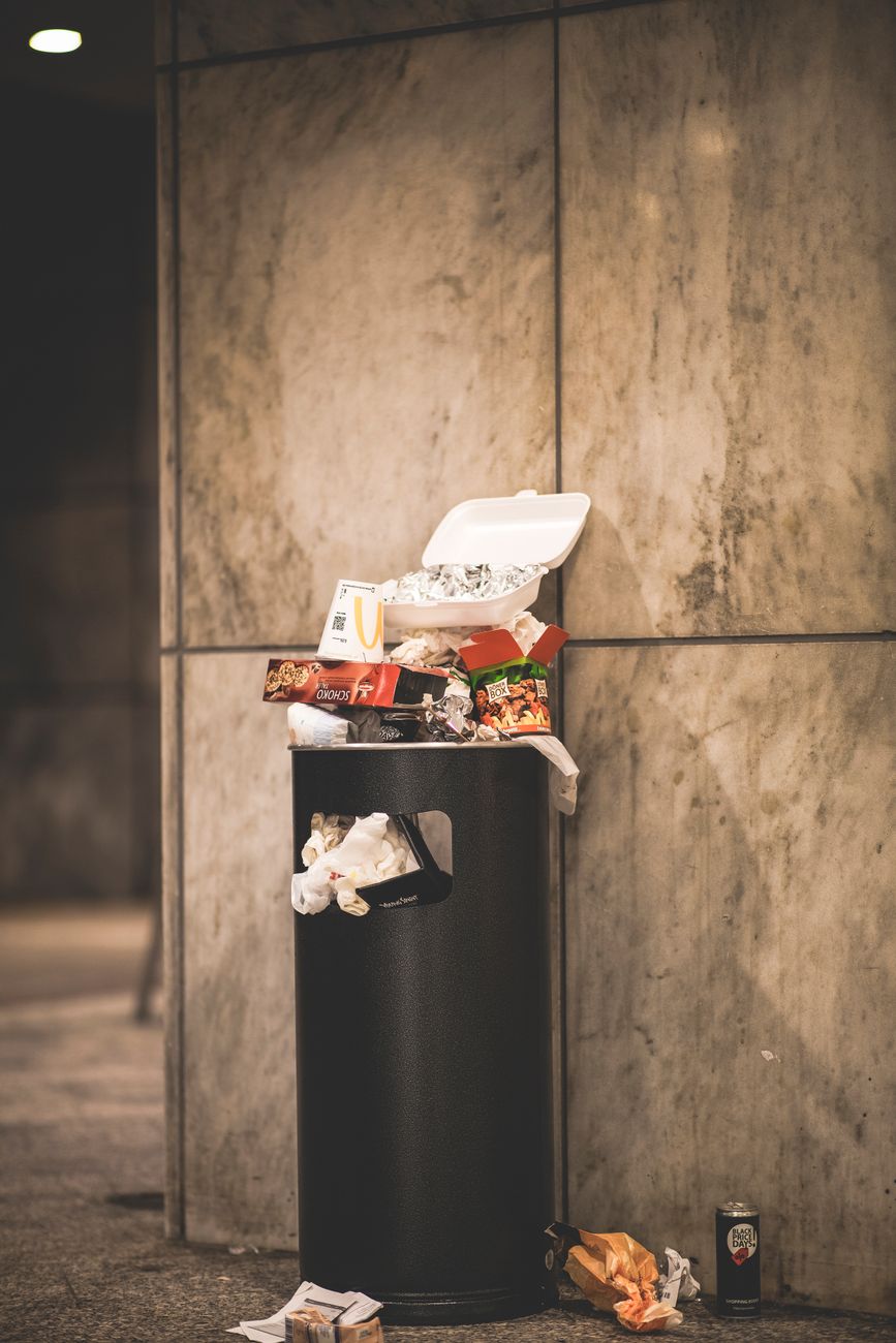 black trash bin with full of trash