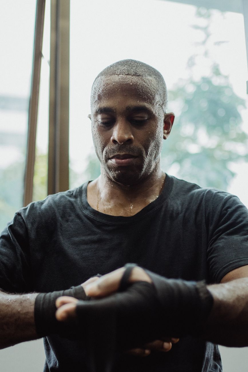 a sportsman in black shirt wrapping his hand
