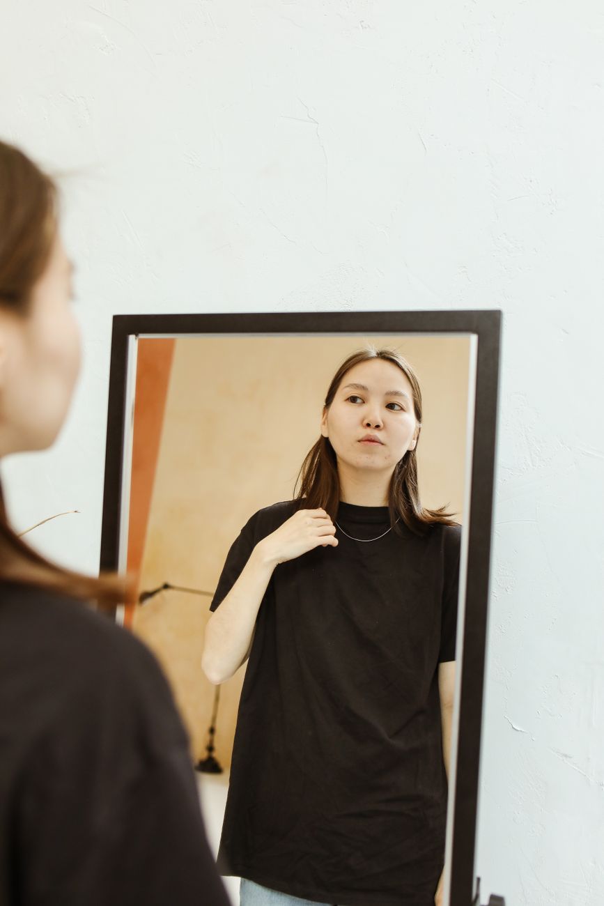 a woman looking herself on a mirror