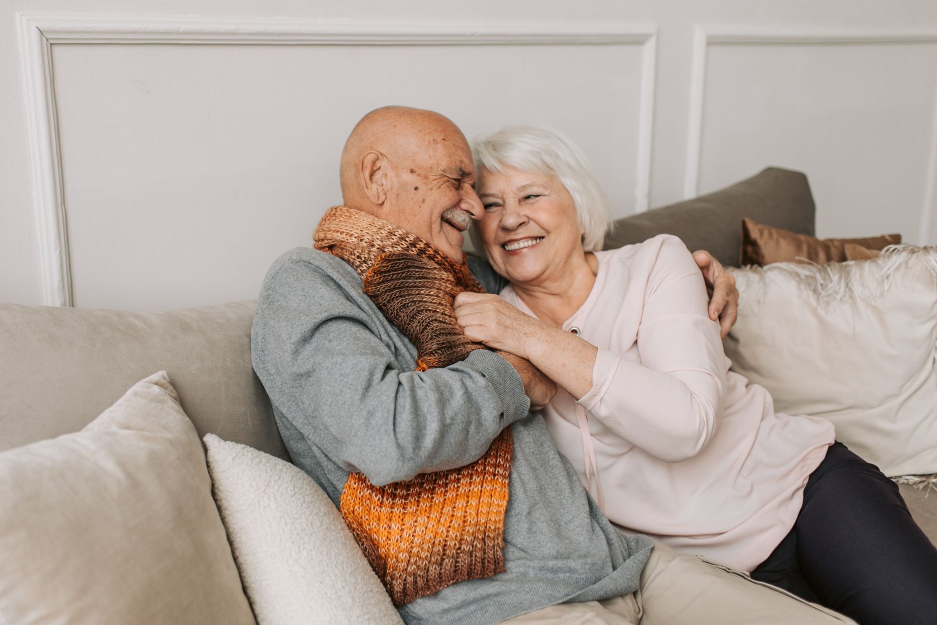 man in gray sweater hugging woman beside him