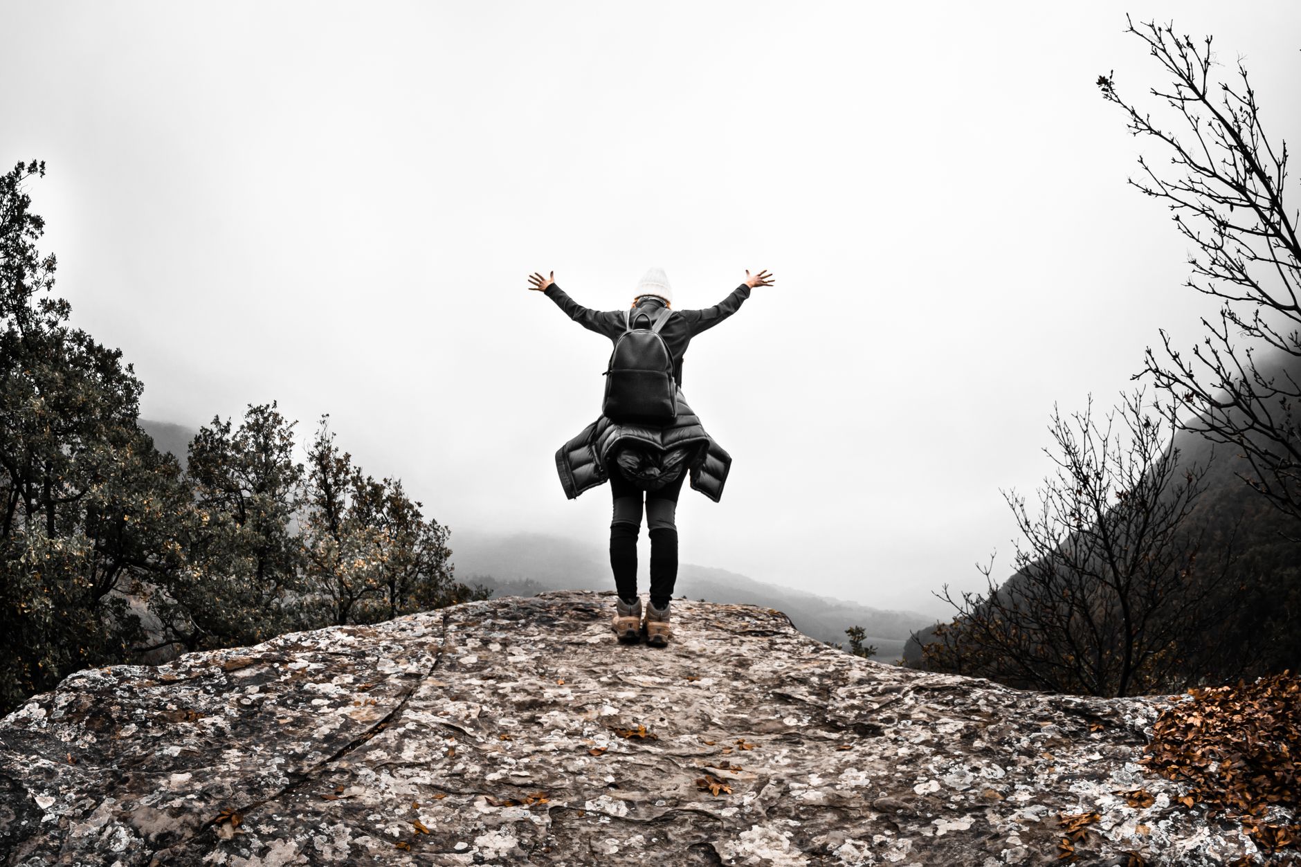 person standing on rock with arm extended