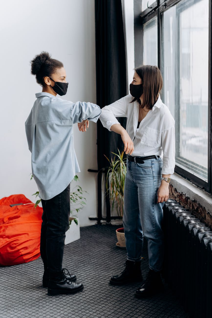 a woman touching elbows as greeting