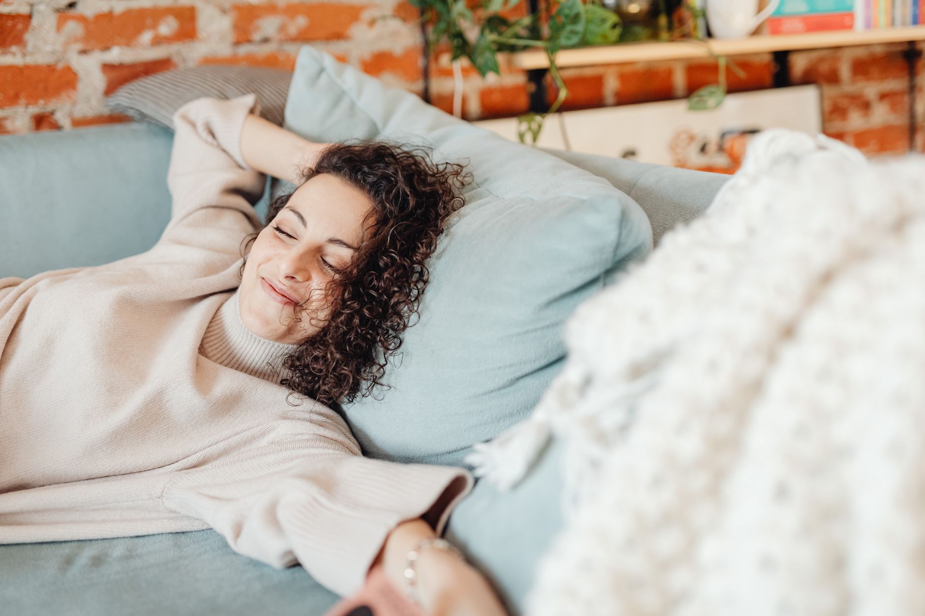 a happy woman lying on a couch