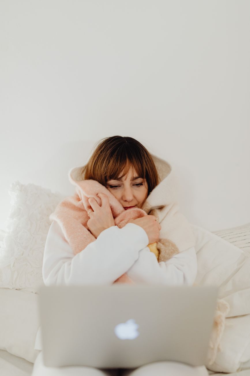 woman using laptop in a bedroom