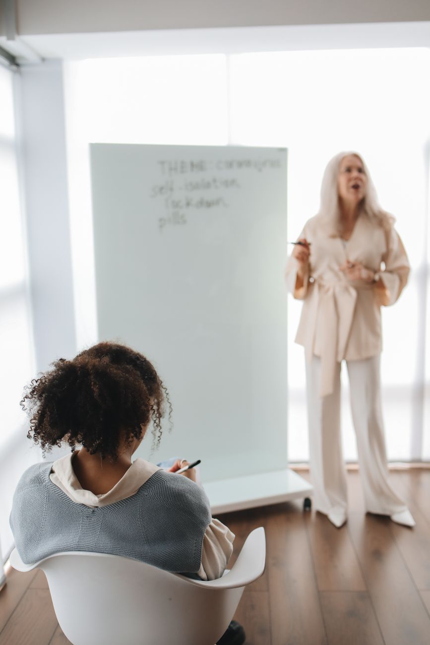 back view of a student listening to her teacher