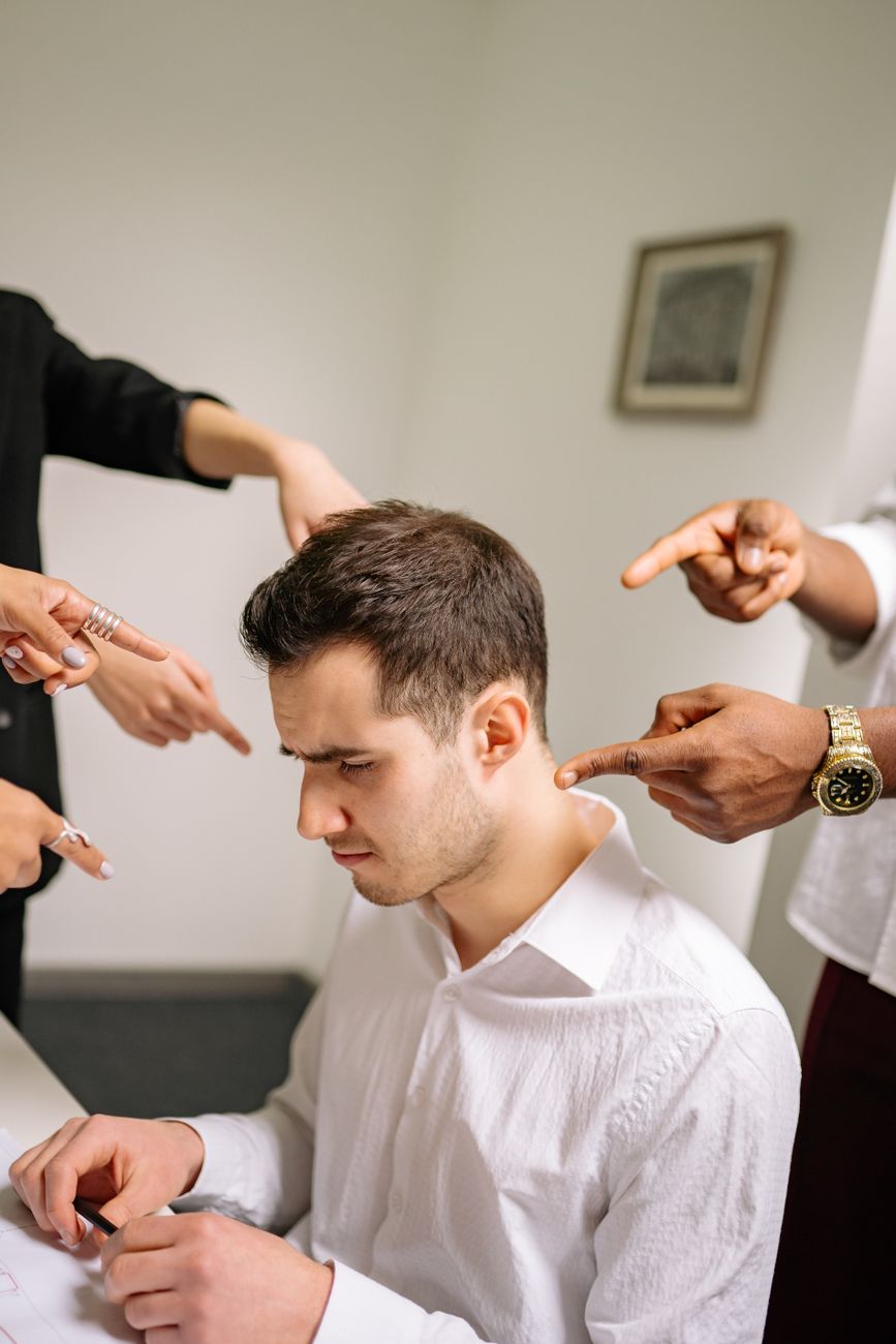 fingers pointing at man in white long sleeves