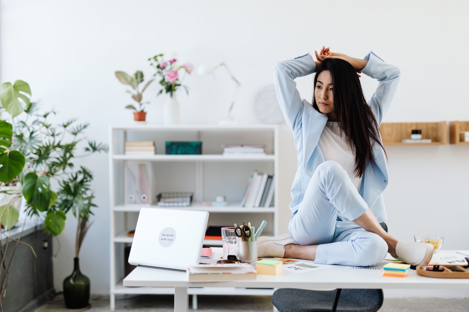 woman in blue blazer and pants sitting on table