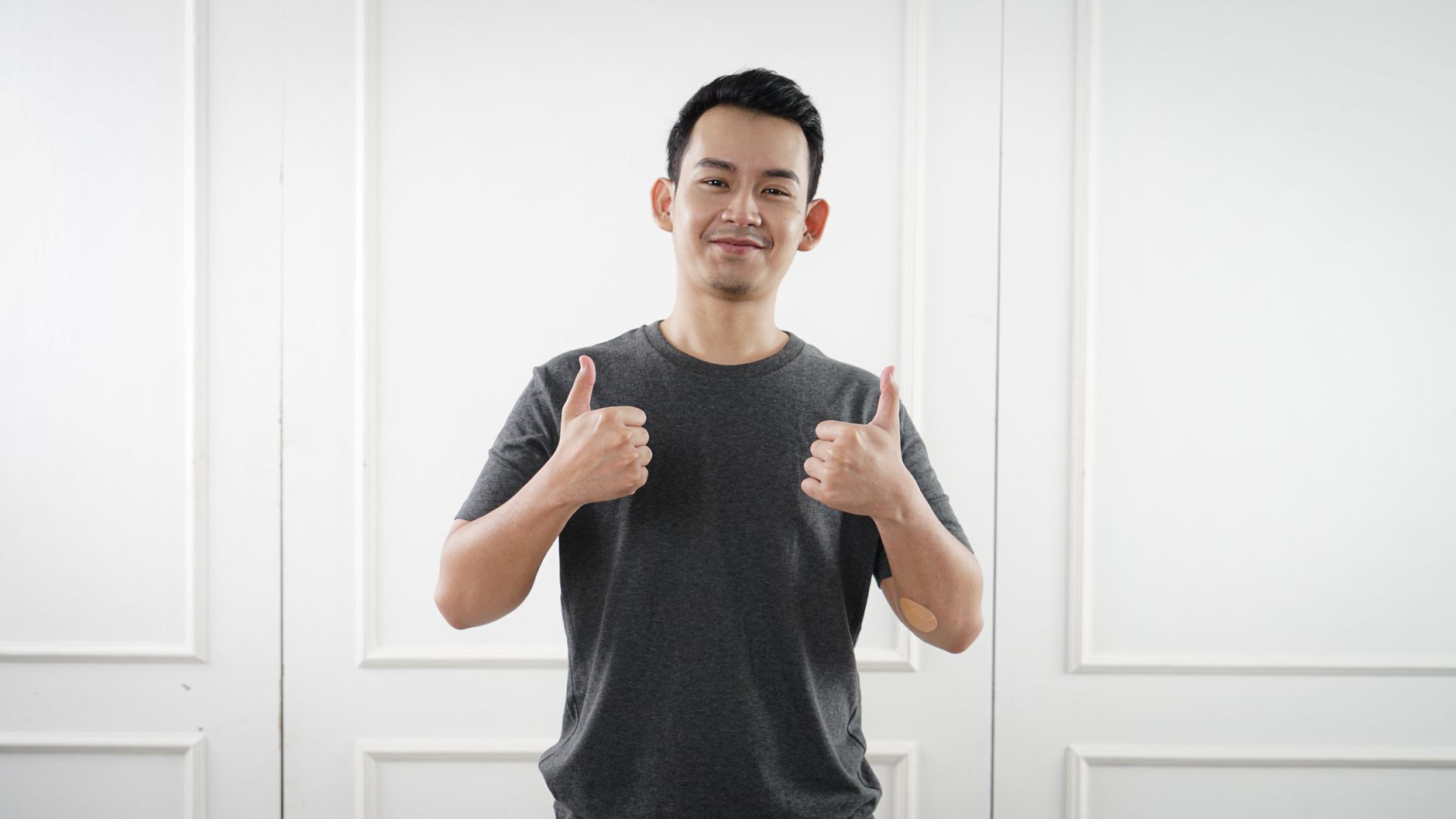 man in gray crew neck shirt with his thumbs up