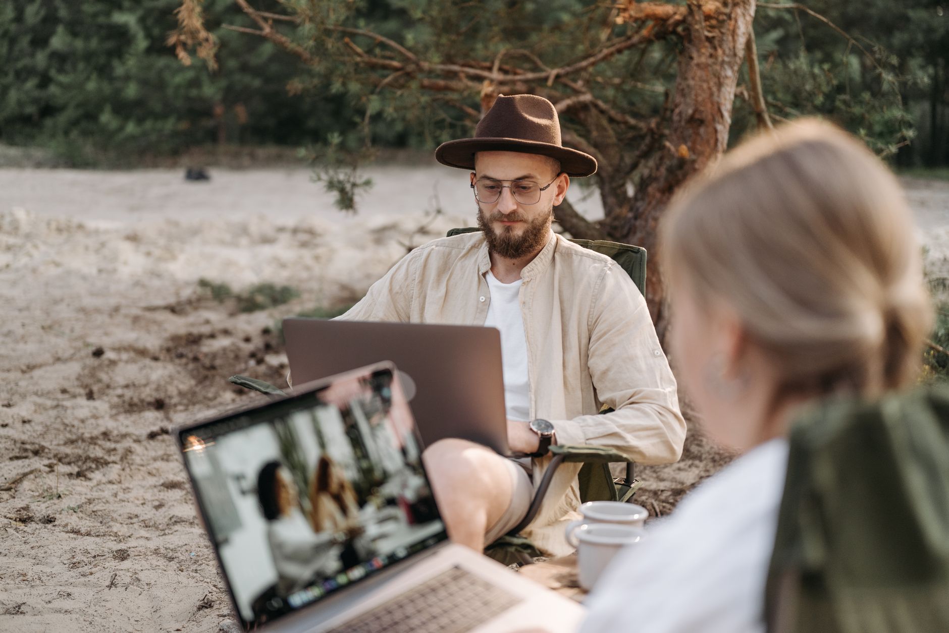 a man wearing a hat using a laptop