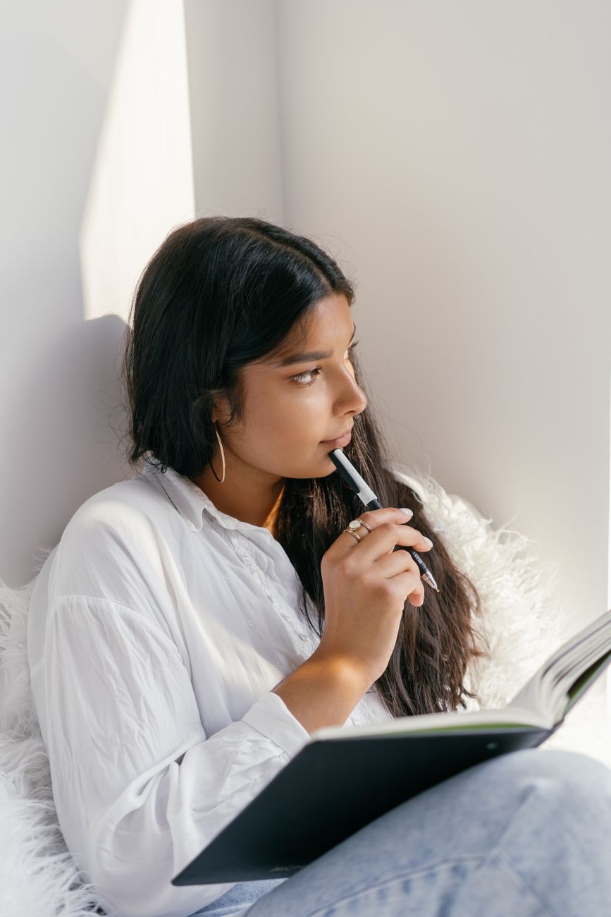 a woman holding a pen and a notebook